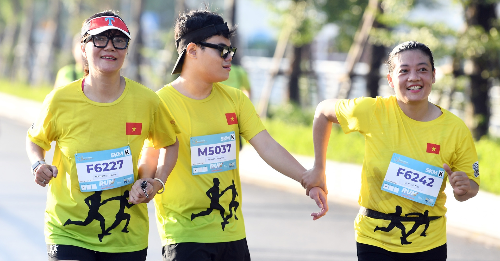 Người khiếm thị được dắt tay ở giải chạy bên Hồ Tây