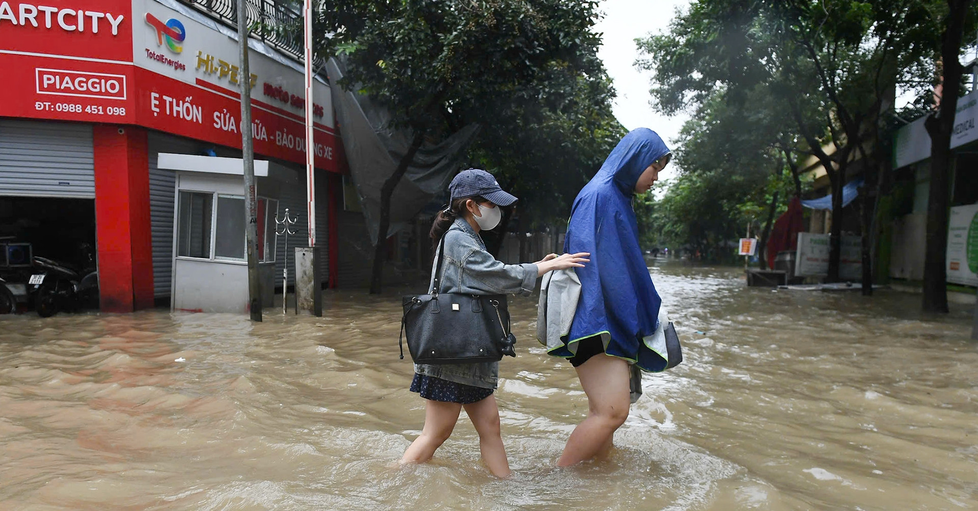 Người Hà Nội dò dẫm tìm đường, dắt xe lội nước trong cơn mưa xối xả