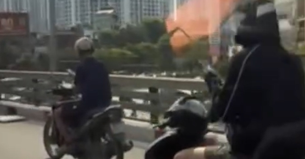 Thanh niên chạy xe máy dùng điện thoại ở Hà Nội...