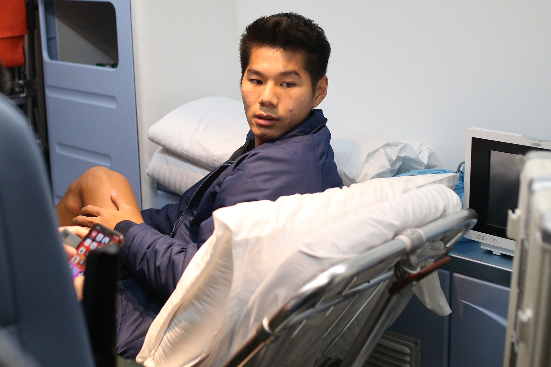 Hiểu Minh ngồi xe lăn về nước, bố đứng khóc từ xa