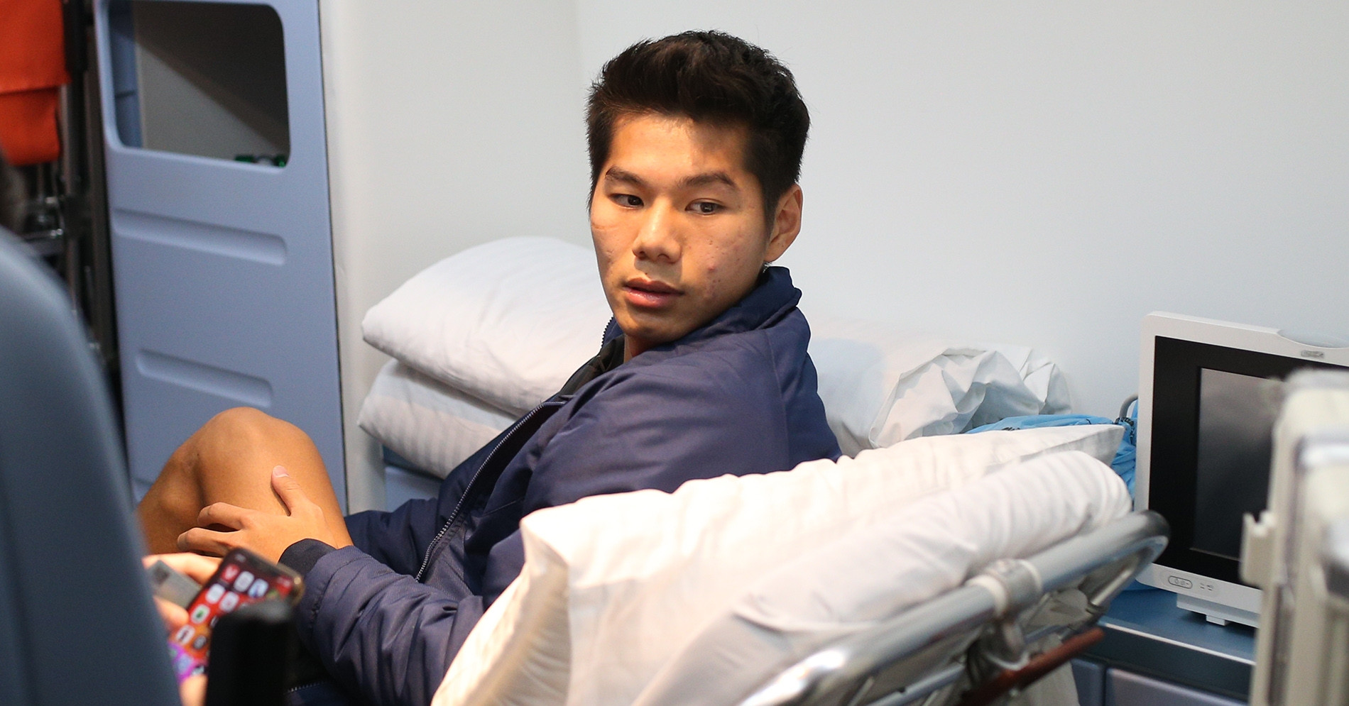 Hiểu Minh ngồi xe lăn về nước, bố đứng khóc từ xa