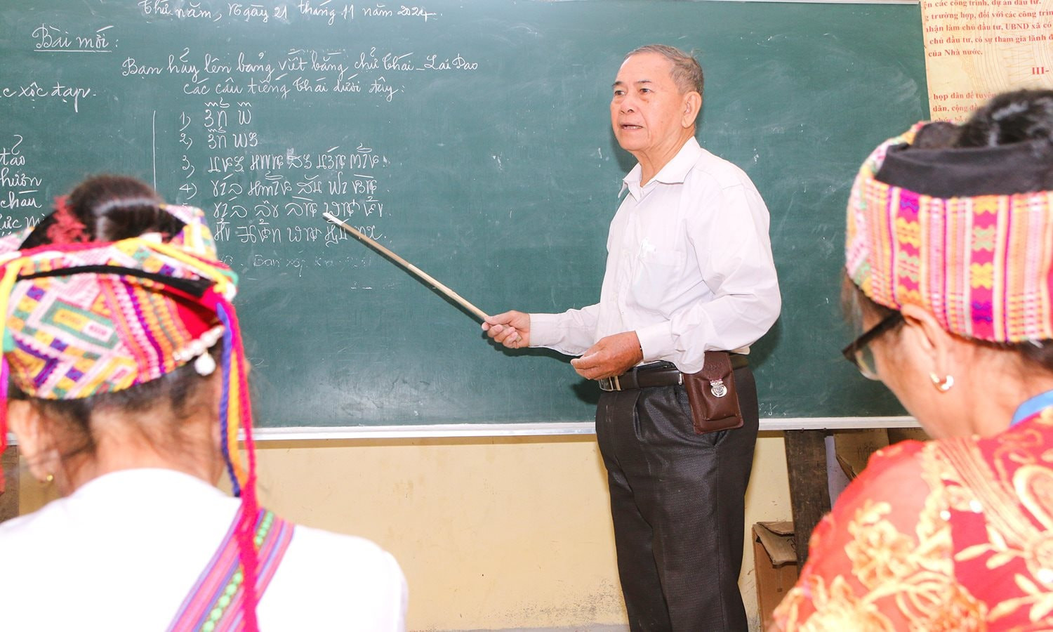 Ông Vi Khăm Mun trong một buổi đứng lớp truyền dạy chữ Thái.jpg