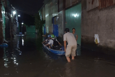 Mưa tạnh hơn một ngày, hẻm ở TPHCM vẫn ngập sâu, dân dùng thuyền đưa con đi học