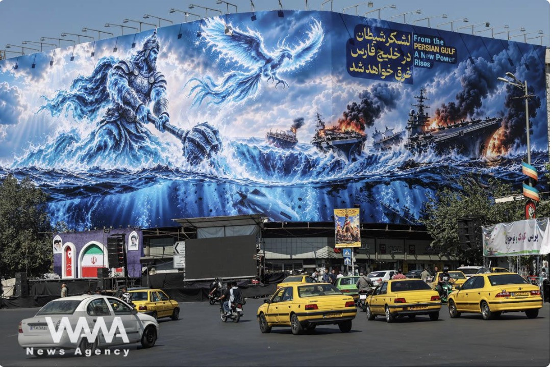 Người dân lái xe ngang qua một poster về Eo biển Hormuz gắn trên một tòa nhà ở Tehran, Iran. Ảnh: WANA