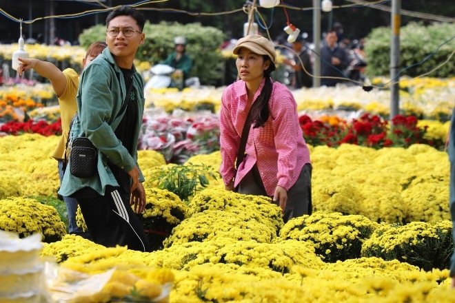 TPHCM mù mịt trong mưa trái mùa, người bán hoa 'ngồi trên đống lửa' ngày cận Tết