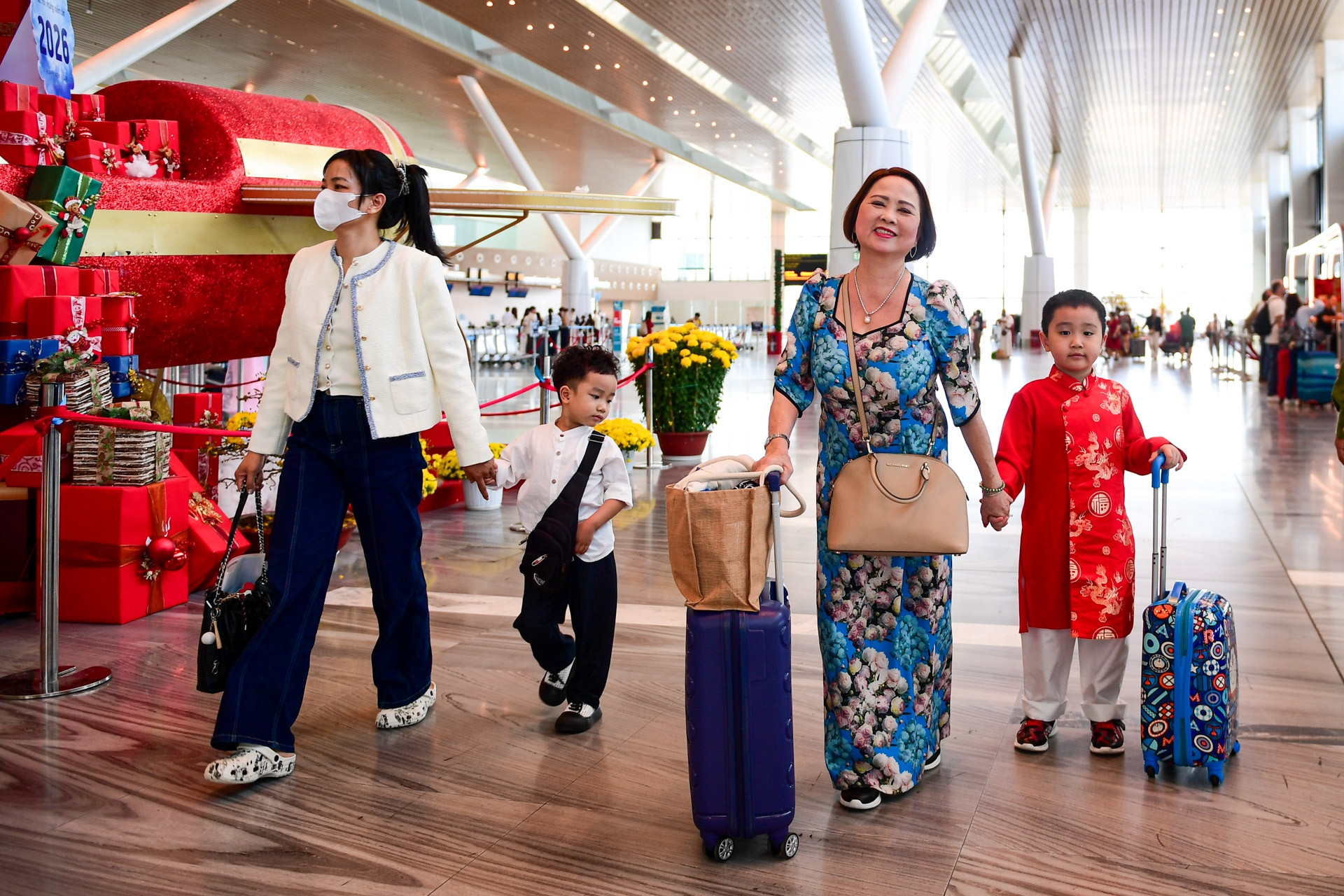 Mùng 1 Tết, hành khách mặc áo dài, ôm hoa mai rộn ràng lên chuyến bay đầu năm