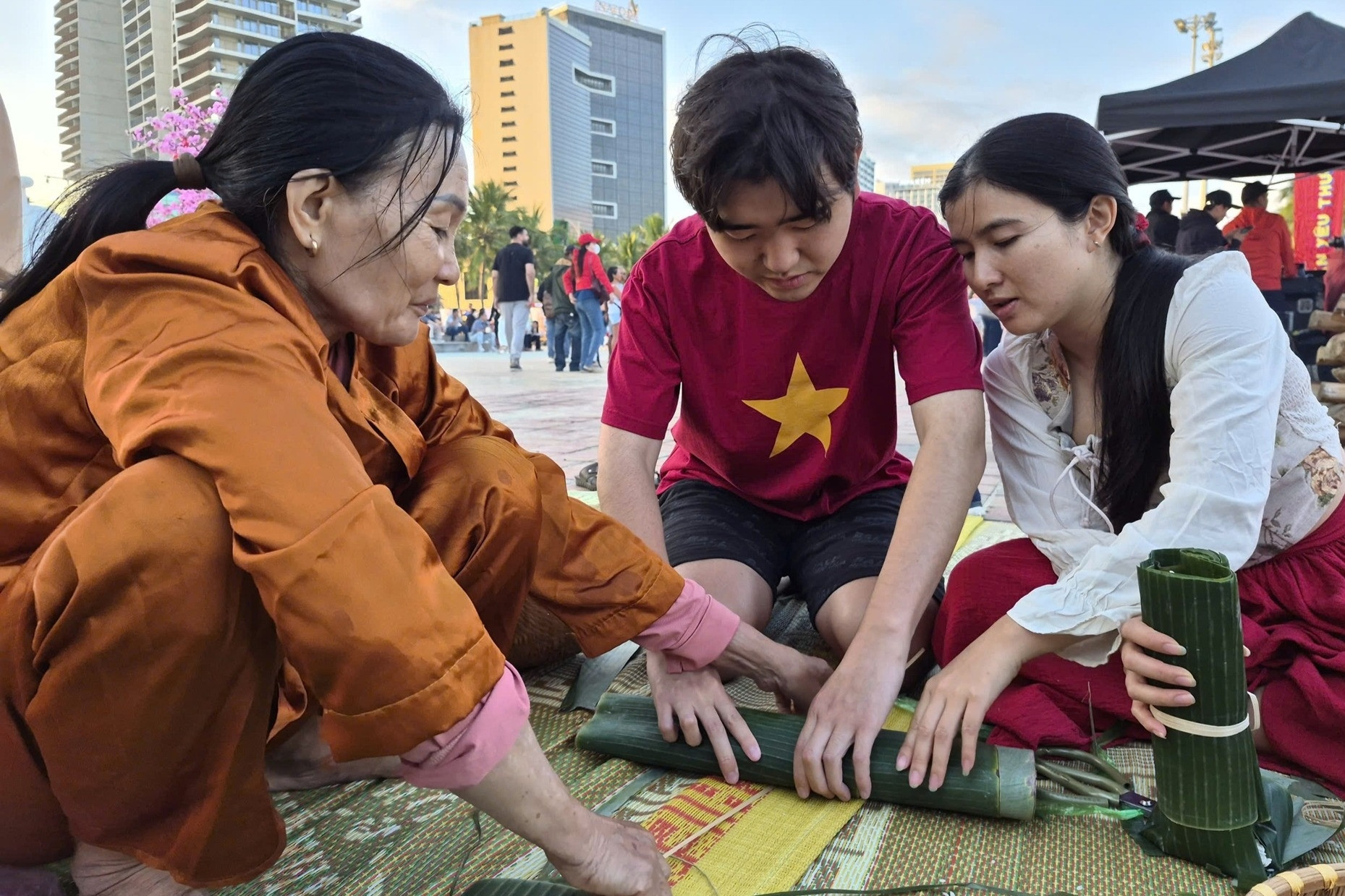 Khách quốc tế thích thú ăn mứt Tết, tự tay gói bánh chưng ở bãi biển Đà Nẵng