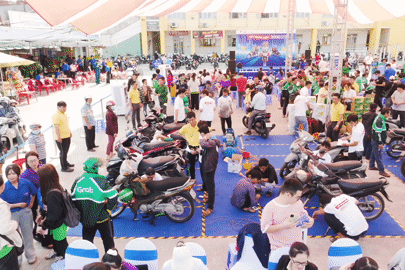 Công nhân vui mừng được thay nhớt xe máy miễn phí trước khi về quê đón Tết