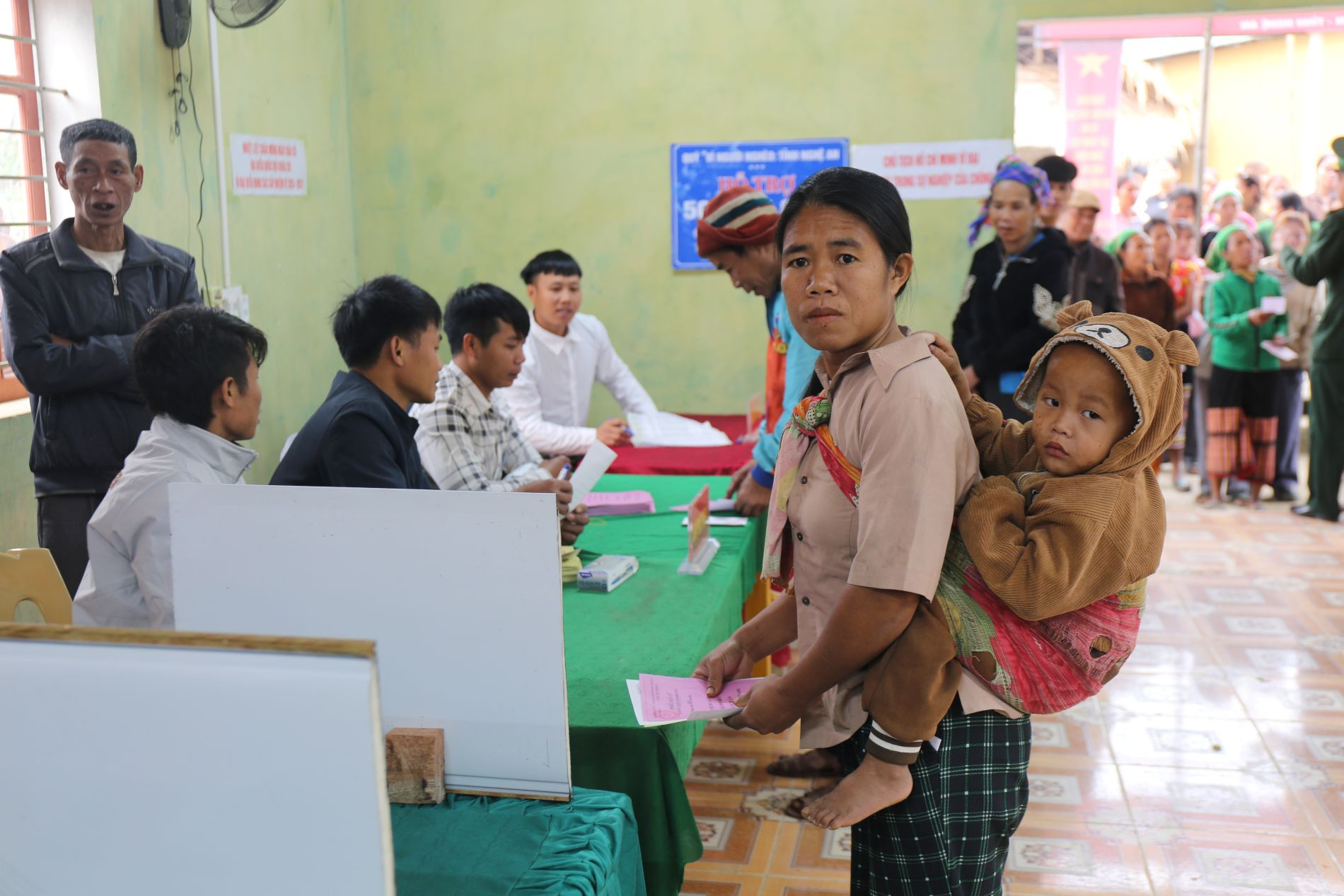 Một phụ nữ người Đan Lai địu con đi bầu cử .JPG