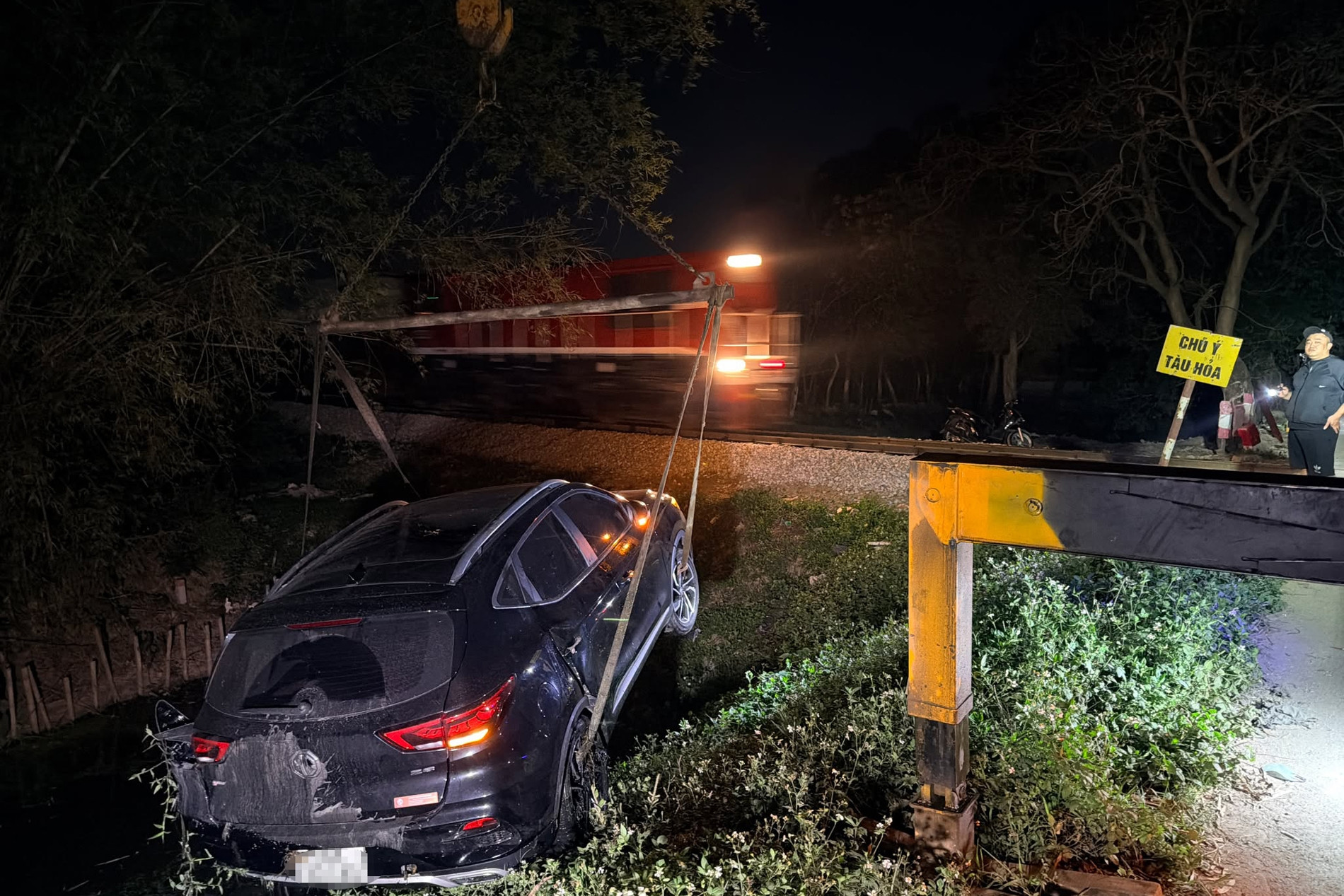 Tàu hỏa hất văng ô tô xuống mương nước ở Hà Nội