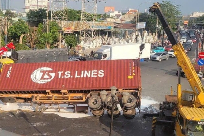 Xe container lật ngang giữa vòng xoay 'tử thần', sơn nước nhuộm trắng mặt đường