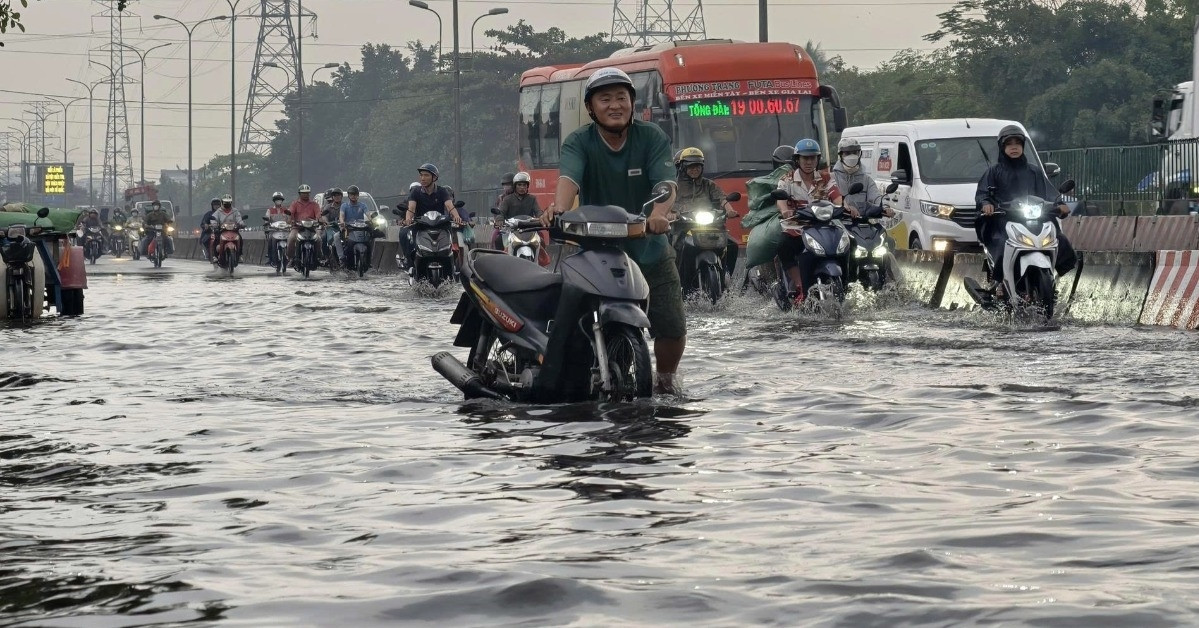 Mưa trái mùa 'nhấn chìm' cửa ngõ TPHCM, người dân bì bõm vượt nước đen về nhà