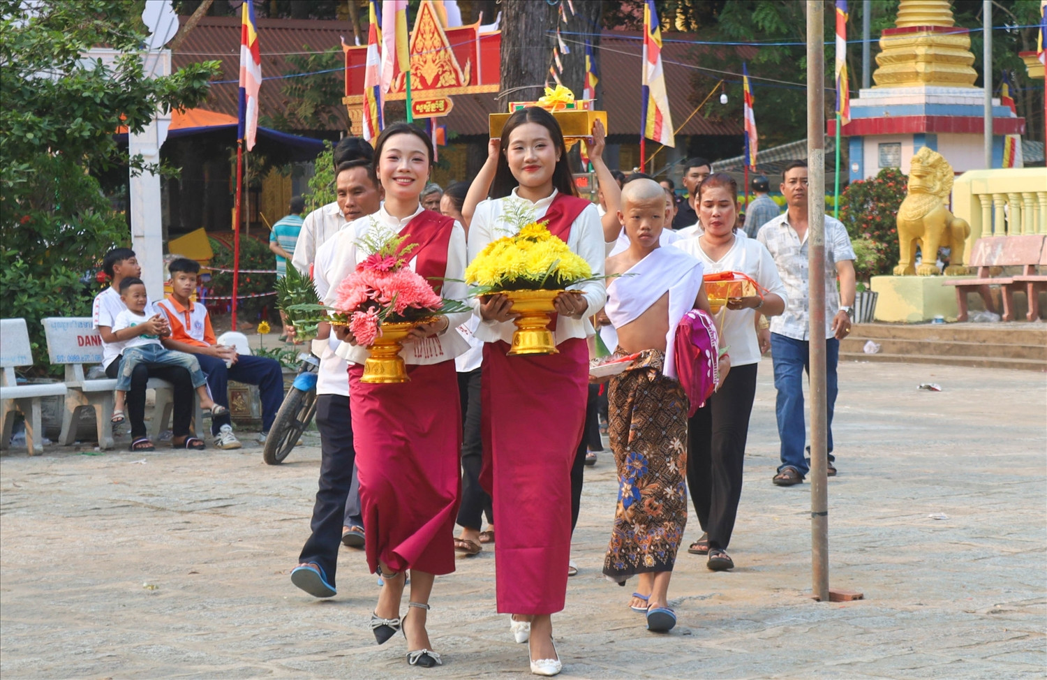 Gia đình mang lễ vật, đưa em nhỏ lên chùa để làm lễ xuất gia