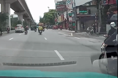 Xe máy chở hàng cồng kềnh kéo ngã cô gái ngay trước đầu ô tô