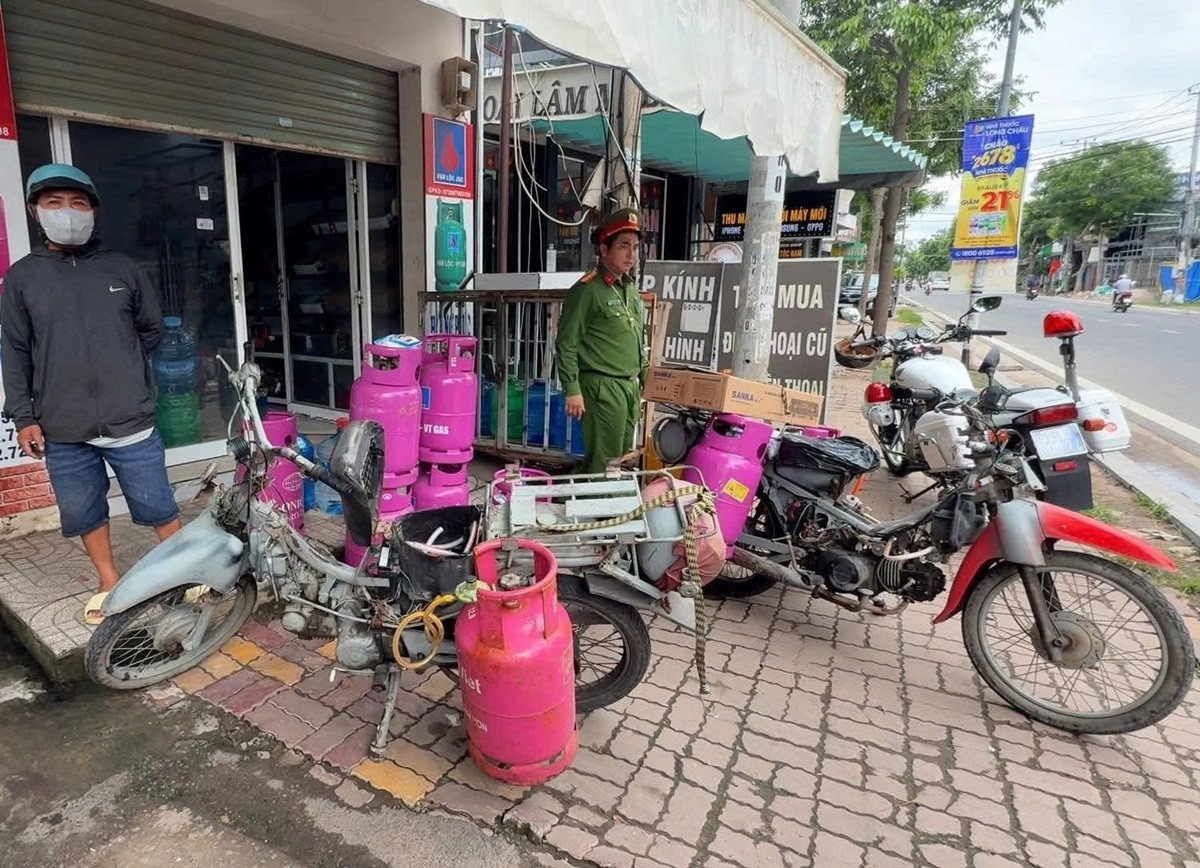 Chủ cửa hàng kinh doanh gas độ 2 xe máy chạy bằng gas để đi giao hàng cho khách.jpg