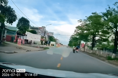 Người phụ nữ đi xe đạp điện tạt đầu xe khác, em bé ngồi sau ngã ngửa ra đường