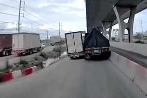 Hai xe tải chen nhau trên đường hẹp, một chiếc bị lộn nhào xuống mương