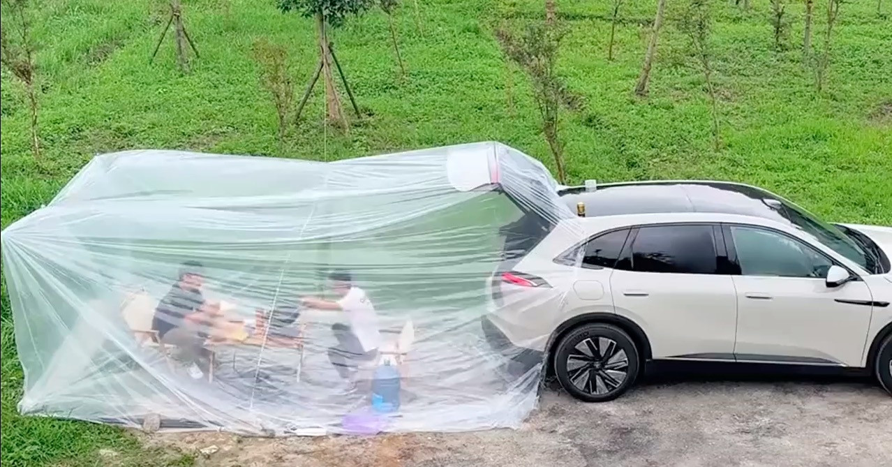 Hai người đàn ông dựng 'phòng điều hòa' sau ô tô để nấu ăn dưới trời nắng nóng