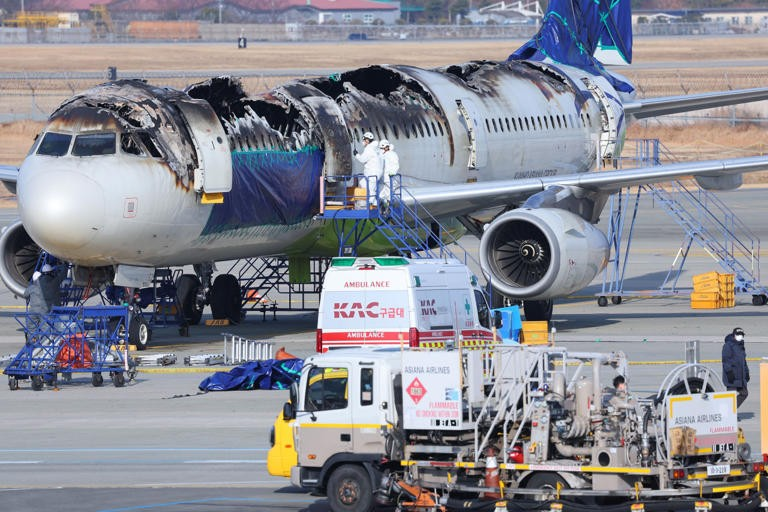 Inspectors examining an Air Busan plane last year after a power-bank fire in an overhead bin. Photo: Yonhap