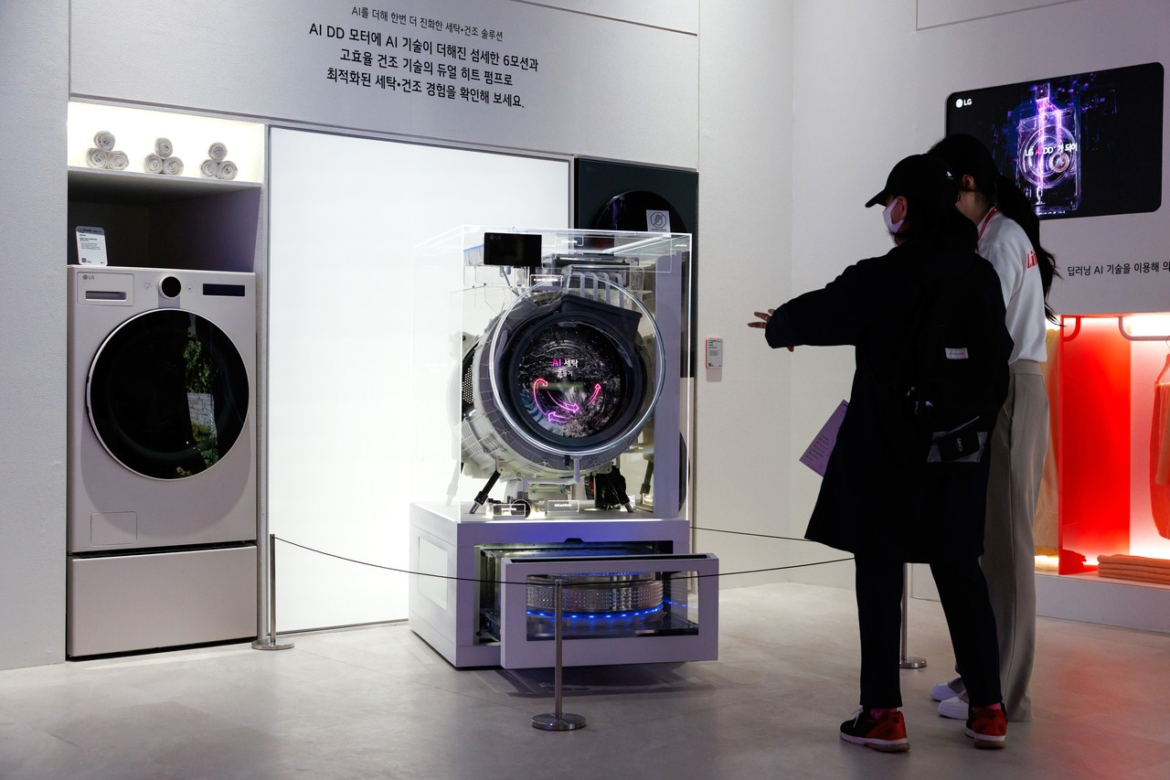 Visitors look at an LG Electronics AI washing machine at the World IT Show in Seoul on April 22. (Bloomberg)
