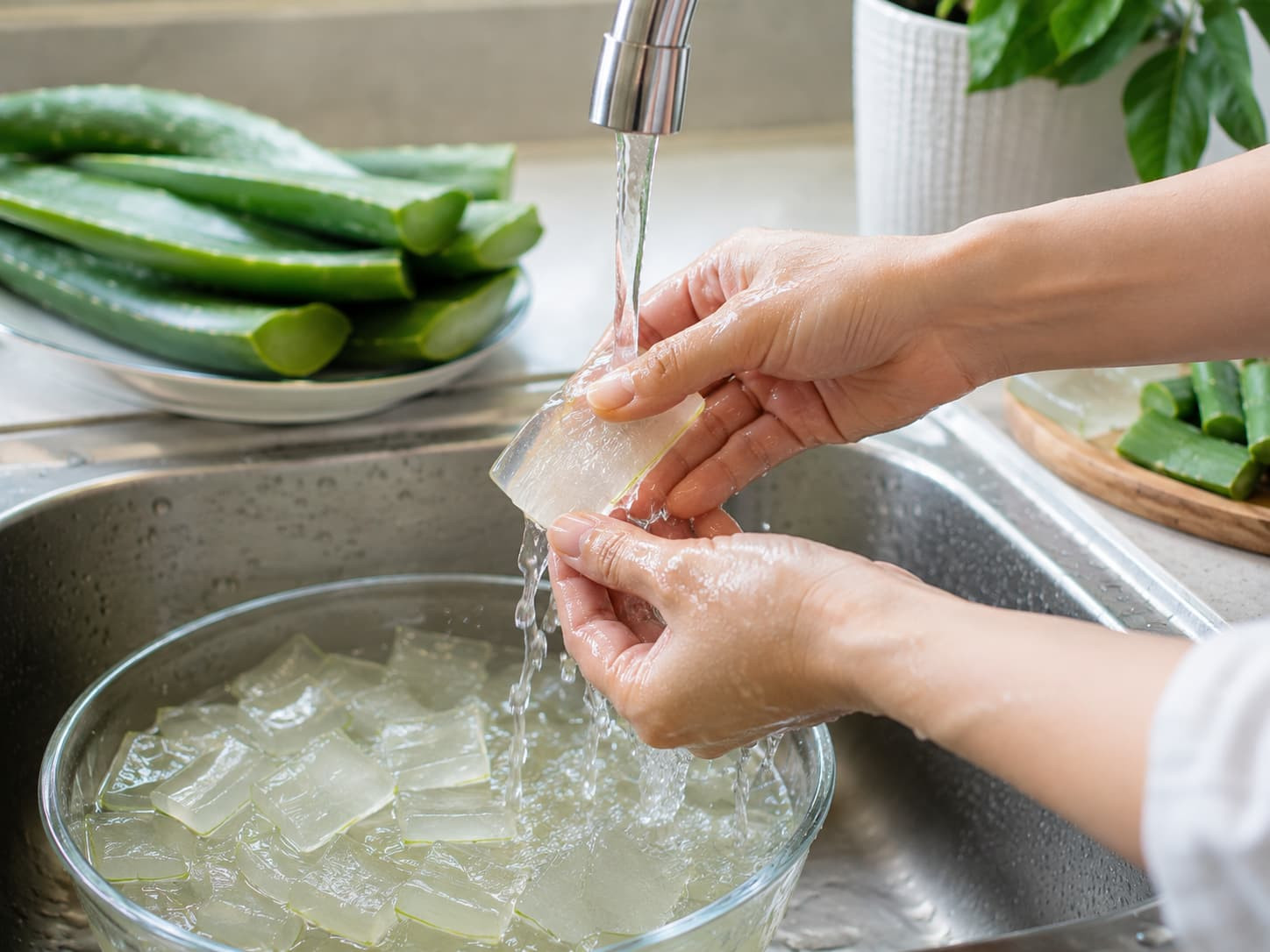 Rửa sạch nha đam dưới vòi nước chảy sau khi đã ngâm muối.jpg
