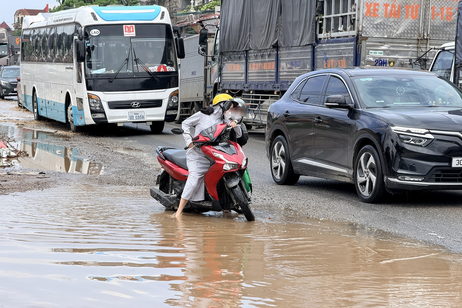 Quốc lộ 6 qua Hà Nội ùn tắc kéo dài, xe máy chật vật né vũng nước
