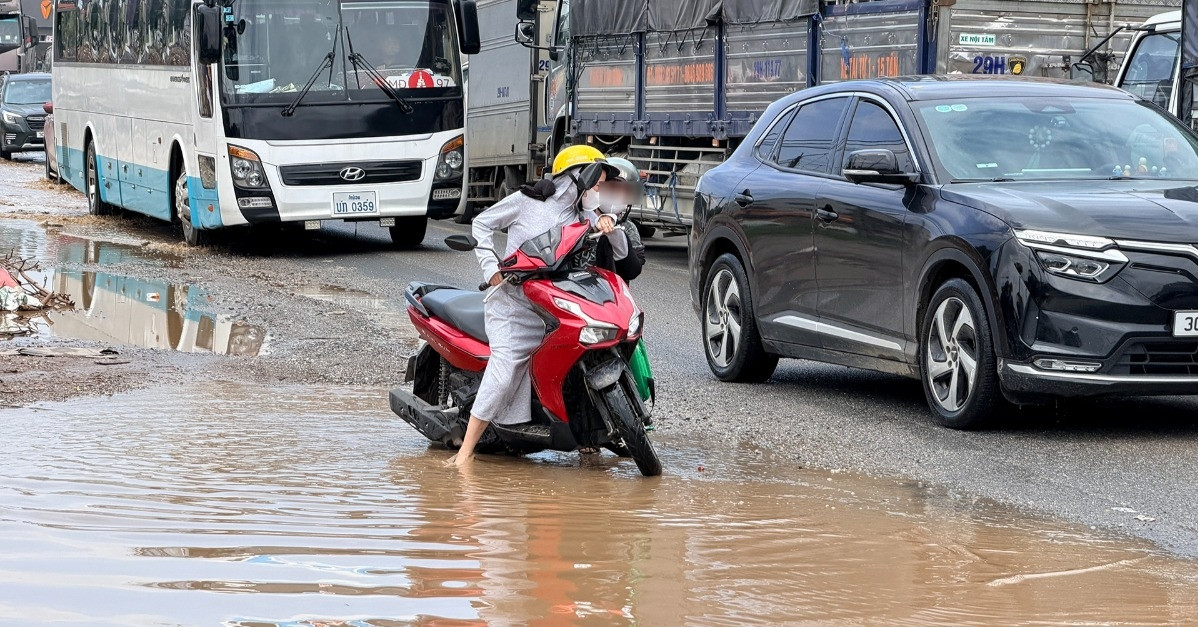 Quốc lộ 6 qua Hà Nội ùn tắc kéo dài, xe máy chật vật né vũng nước