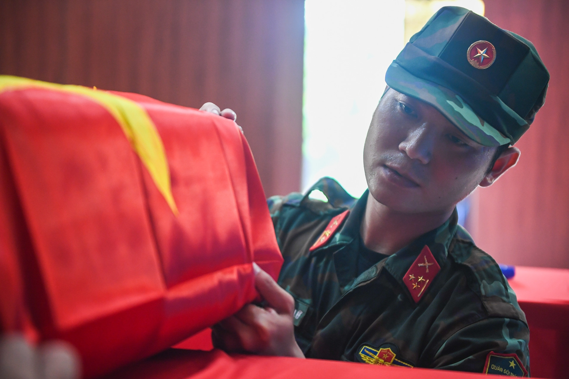 Chiến sĩ trẻ tự nguyện nhận nghi thức phủ Quốc kỳ lên hài cốt liệt sĩ