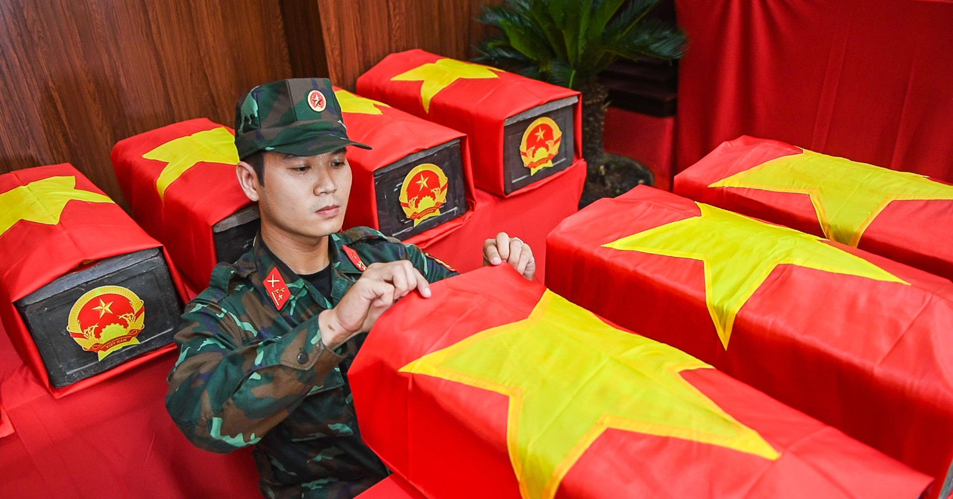 Chiến sĩ trẻ tự nguyện nhận nghi thức phủ Quốc kỳ lên hài cốt liệt sĩ