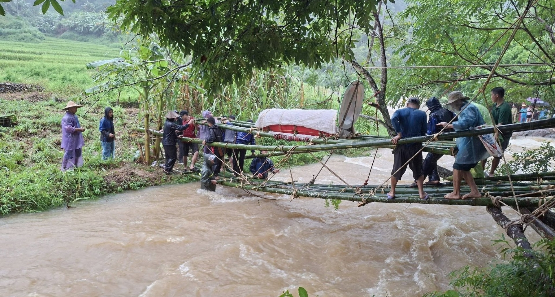 Mưa lũ chặn đường, cả làng chặt tre làm cầu đưa người quá cố qua suối dữ