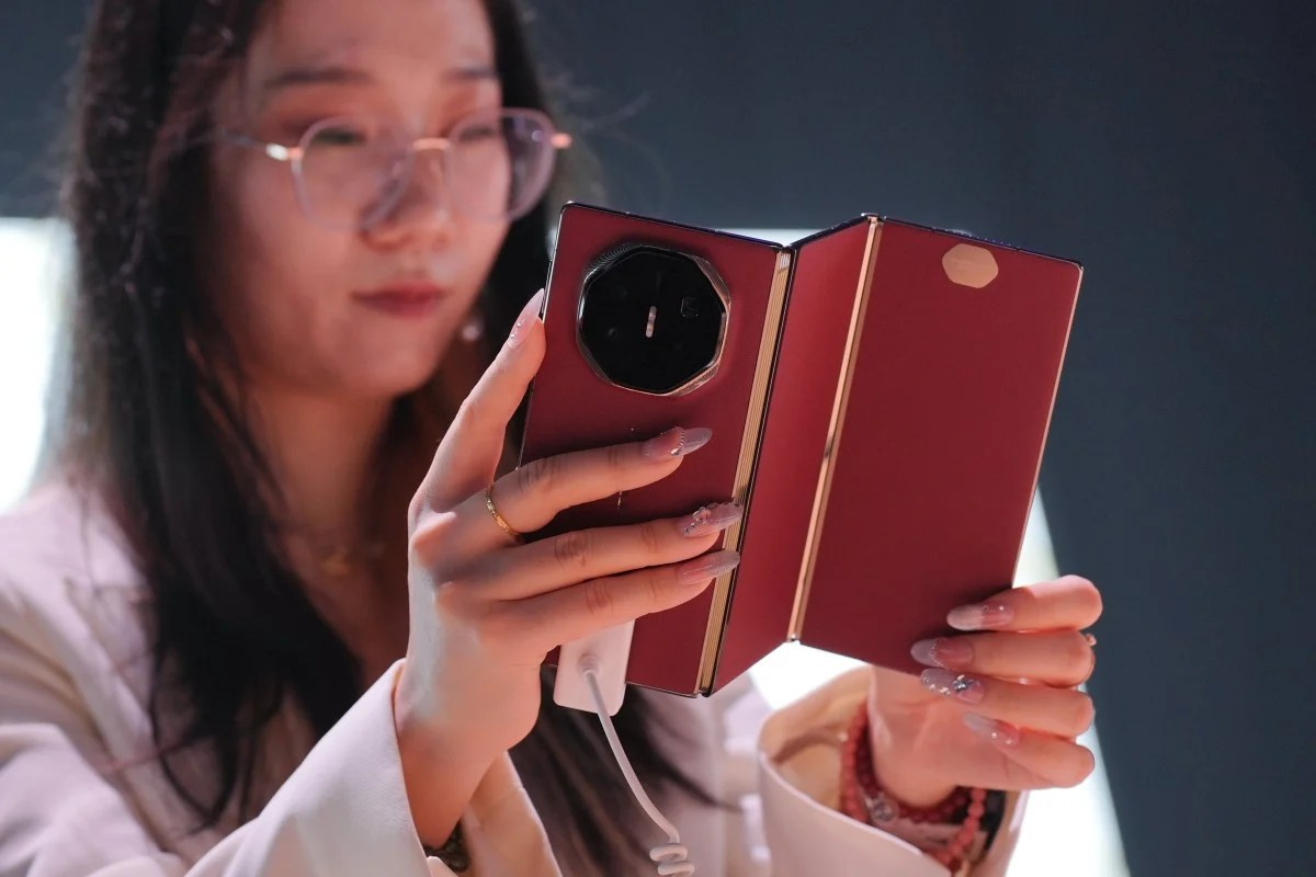 A Huawei staff member holds a Mate XT tri-fold smartphone during a product launch event last year. The Chinese tech giant unveiled the Huawei Mate XT, the world’s first tri-fold smartphone, for its international market. Photo: EPA-EFE