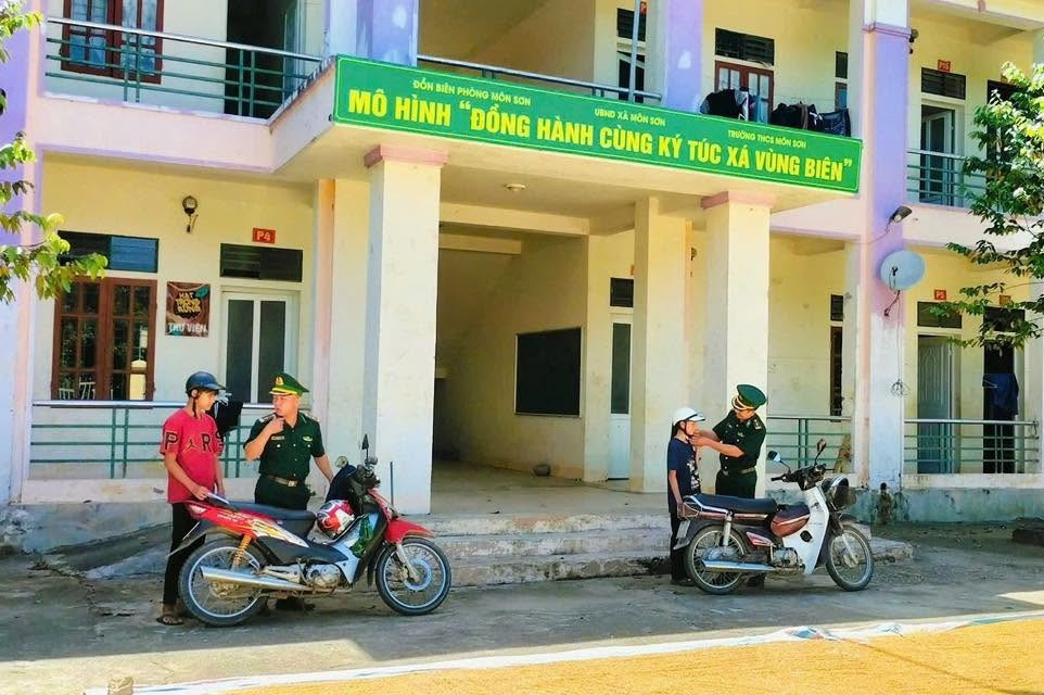 Cán bộ Đồn Biên phòng Môn Sơn hỗ trợ đưa học sinh đến trường.