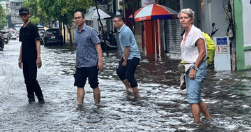 Tourists wade through flooded streets in HCM City's downpour