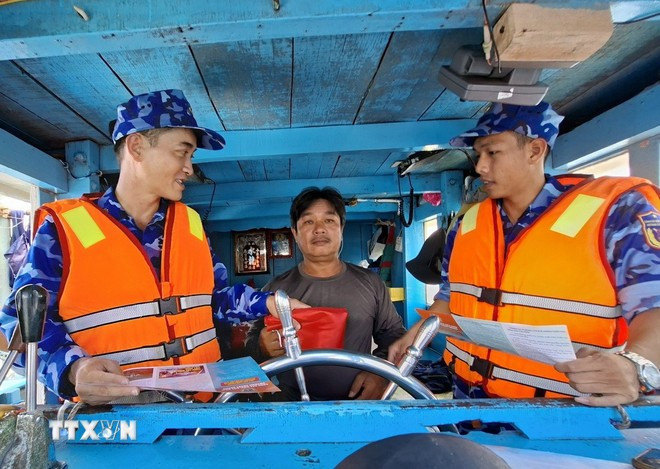 Law enforcement officers of Ho Chi Minh City disseminate anti-IUU fishing regulations to a fisherman. (Photo: VNA)