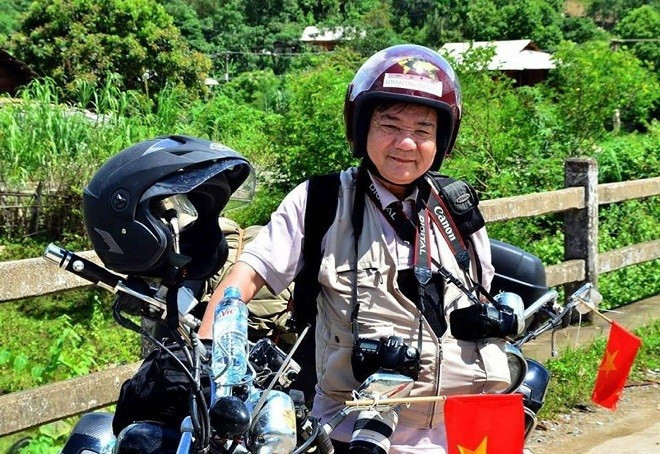 Nhà báo Ngô Minh Đạo trong một lần đi chụp ảnh bằng xe máy.jpg