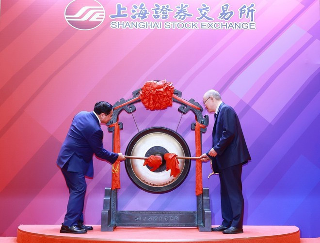 Prime Minister Pham Minh Chinh (L) performs the gong-beating ceremony to open a trading session at the Shanghai Stock Exchange. (Photo: VNA)