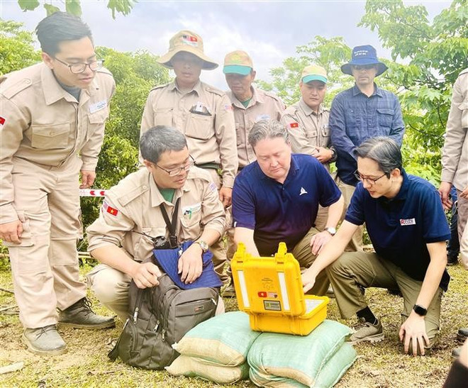 Deputy Minister of Foreign Affairs Do Hung Viet (right) and US Ambassador to Vietnam Marc E. Knapper (centre) press the button to defuse a wartime bomb in Quang Tri province. (Photo: VNA)