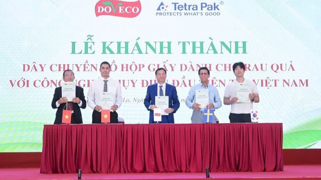 The signing ceremony of cooperation deals between Doveco and units trading products in large quantities and in the long-term. (Photo: nhandan.vn)