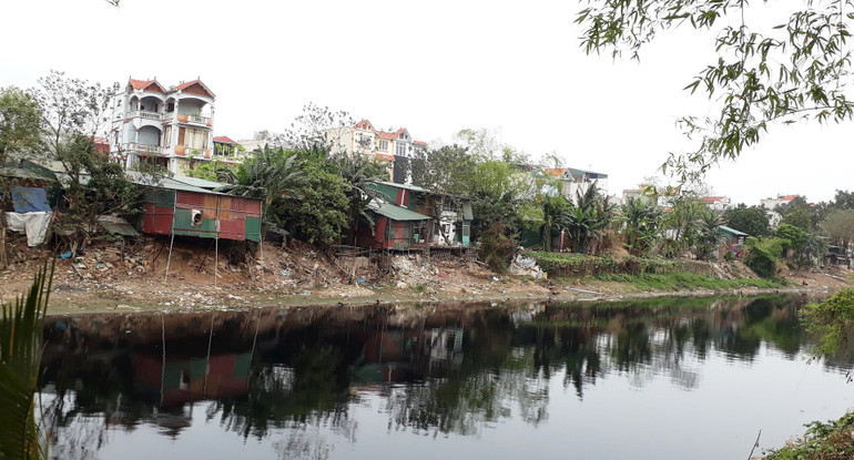 Đoạn sông Nhuệ chảy qua huyện Thanh Trì vừa ô nhiễm, vừa bị lấn chiếm. Ảnh HẢI MIÊN