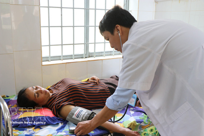 A local resident seeks medical examination at the health station of Cuor Dang commune, Dak Lak province. (Photo: VNA)
