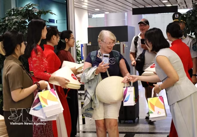 Gifts are presented to passengers arriving on two new international routes from Manila and Bali. (Photo: VNA)